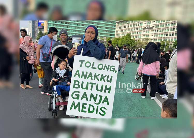 AKSI DAMAI: Seorang ibu membawa poster bertuliskan "Tolong, Anakku Butuh Ganja Medis" pada Car Free Day (CFD) di Bundaran HI, Jakarta, Minggu (26/06). (Ant/Lingkar.news)
