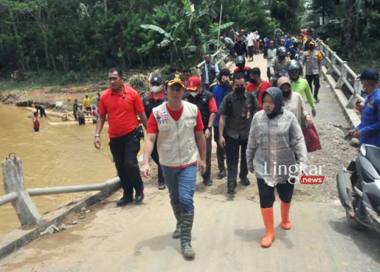 MENINJAU: Mensos Risma (kanan) didampingi Bupati Trenggalek Mochamad Nur Arifin (kiri) dan jajaran forkopimda saat meninjau dampak banjir bandang di Munjungan, Trenggalek, Jawa Timur pada Minggu, 6 November 2022. (Istimewa/Lingkar.news)