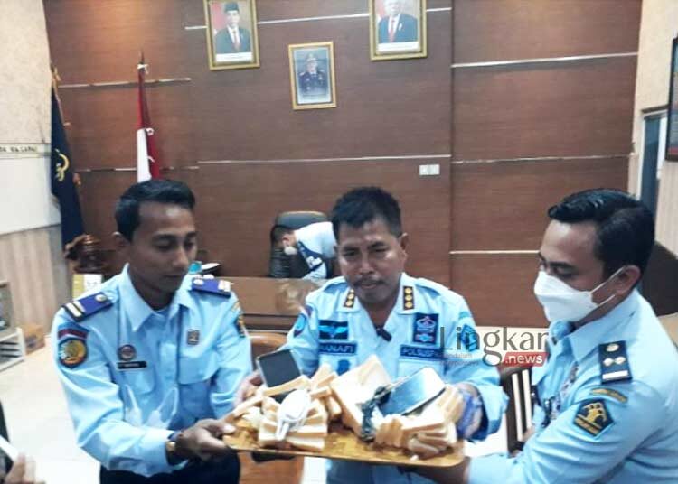 BARANG BUKTI: Petugas saat ungkap kasus roti berisi telepon seluler yang hendak diselundupkan kepada tahanan narkoba di Lapas Kelas II A Kediri, Jawa Timur pada Selasa, 22 November 2022. (Istimewa/Lingkar.news)