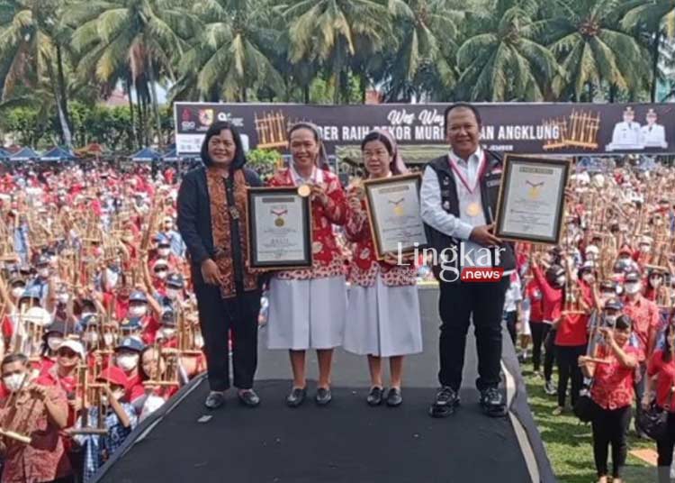 MERAIH REKOR: Bupati Jember, Hendy Siswanto (kanan) bersama Eksekutif Manager MURI Sri Widayati (kiri) dan penyelenggara usai menerima piagam penghargaan MURI dalam Gebyar Angklung di Alun-Alun Jember pada Rabu, 16 November 2022. (Istimewa/Lingkar.news)