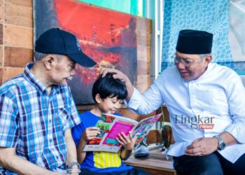 MEMBACA: Wali Kota Tangerang Selatan Benyamin Davnie (kanan) saat melihat seorang anak membaca buku di Taman Baca Masyarakat. (istimewa/Lingkar.news)