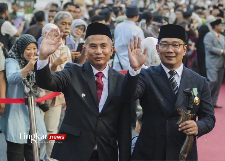 Penjabat Gubernur Jawa Barat Bey Triadi Machmudin (kiri) didampingi Gubernur Jawa Barat periode 2018-2023 Ridwan Kamil (kanan) melambaikan tangan usai penandatanganan serah terima jabatan di Gedung Sate, Bandung, Jawa Barat, pada Selasa, 5 September 2023. (Antara/Lingkar.news)