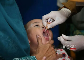 Salah seorang anak di Kota Surabaya mendapatkan imunisasi polio dari petugas kesehatan. (Antara/Lingkar.news)