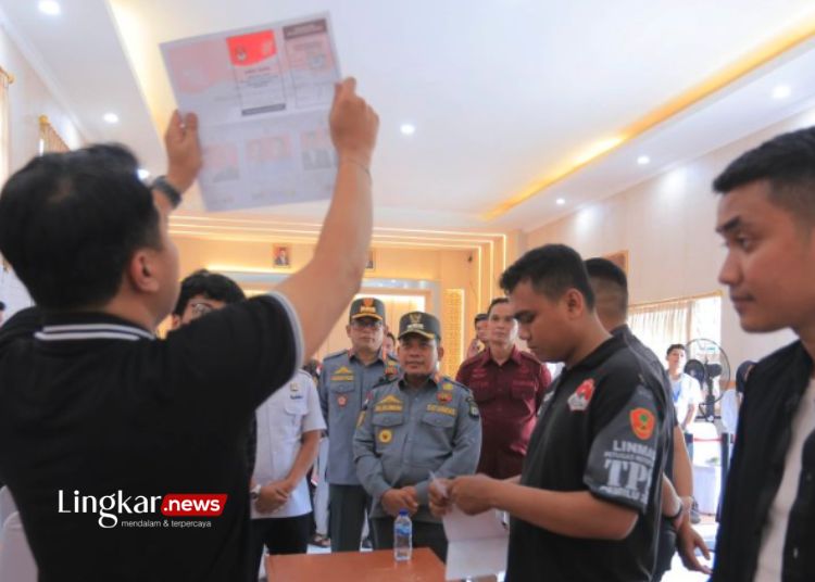 PEMILU: Seorang anggota KPPS sedang mengangkat surat suara dalam kegiatan penghitungan tanggal 14 Februari 2024. (Antara/Lingkar.news)