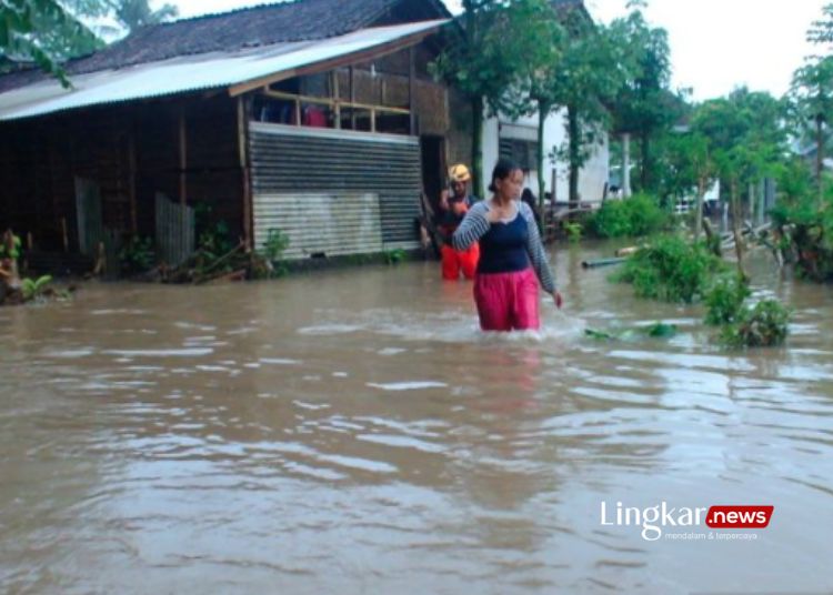 BANJIR: Warga melintas di sekitar rumah yang terendam banjir di Kecamatan Bangsalsari, Kabupaten Jember, Jatim, Jumat, 8 Maret 2024. (Antara/Lingkar.news)