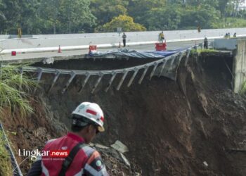 MENINJAU: Petugas melintas di sekitar jalan tol yang amblas di ruas tol Bocimi KM 64, Sukabumi, Jawa Barat, Kamis, 4 April 2024. (Antara/Lingkar.news)
