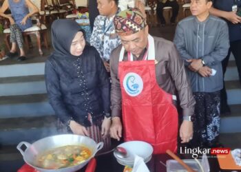 MEMASAK: Penjabat Bupati Jepara Edy Supriyanta didampingi istri turut memasak pindang serani dalam event pemecahan rekor Muri penyajian 9.783 porsi pindang serani, Jumat, 26 April 2024. (Muhammad Aminudin/Lingkar.news)