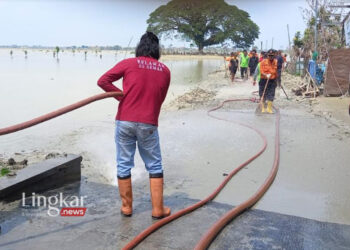 GOTONG ROYONG: Personel Satpol PP (Damkar) beserta unsur terkait berjibaku memembersihkan lumpur sisa banjir di Karanganyar, belum lama ini. (M Burhanuddin Aslam/Lingkar.news)