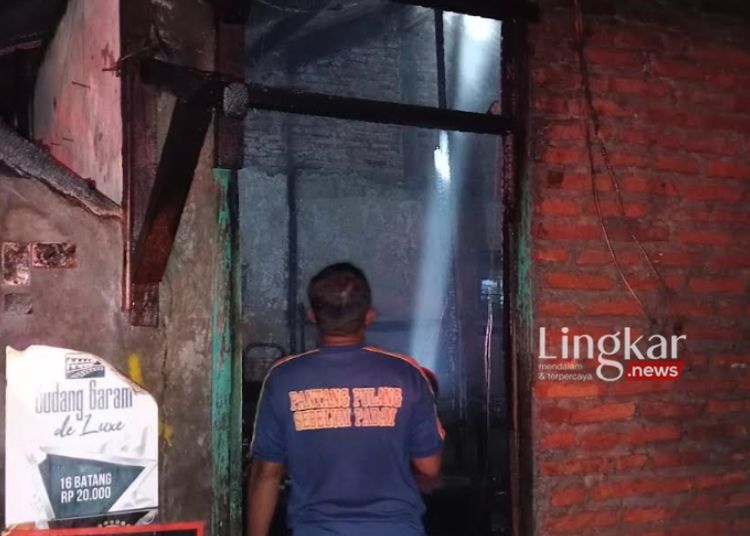 Personel Satpol PP Demak melalui bidang Pemadam Kebakaran (Damkar) saat membantu memadamkan api yang melahap toko sembako di Desa Menur RT 04 RW 02, Kecamatan Mranggen, Kabupaten Demak pada Rabu 8 Mei 2024. (M Burhanuddin Aslam/Lingkar.news)