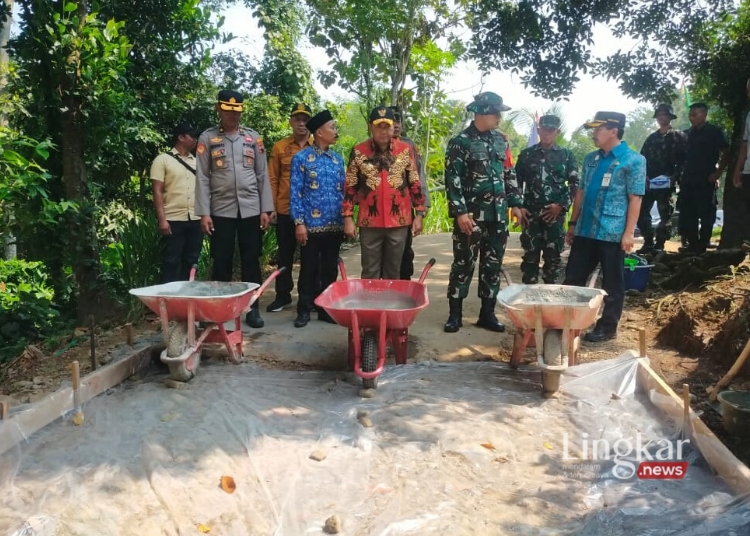 SIMBOLIS: Penjabat Bupati Jepara Edy Supriyanta (tengah) didampingi Sekda Jepara Edy Sujatmiko (kanan) dan Dandim 0719/Jepara Letkol Inf. Mokhamad Husnur Rofiq bersiap menuangkan semen di jalan yang akan dibangun dalam program TMMD Sengkuyung Tahap II Tahun 2024 di Desa Tunahan, Kecamatan Keling, Kabupaten Jepara, Rabu, 8 Mei 2024. (Muhammad Aminudin/Lingkar.news)