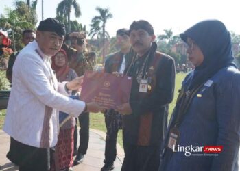SIMBOLIS: Penjabat Bupati Jepara, Edy Supriyanta, menyerahkan hadiah kepada pegawai yang berprestasi usai upacara Hardiknas di Alun-Alun Jepara pada Kamis, 2 Mei 2024. (Muhammad Aminudin/Lingkar.news)