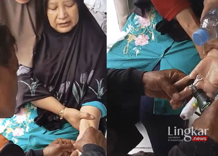 Petugas Satpol PP Kabupaten Demak melalui bidang pemadam kebakaran melepaskan cincin di jari seorang ibu-ibu paruh baya warga Kelurahan Singorejo RT 01 RW 02 Kecamatan Demak. (M. Burhanuddin Aslam/Lingkar.news)