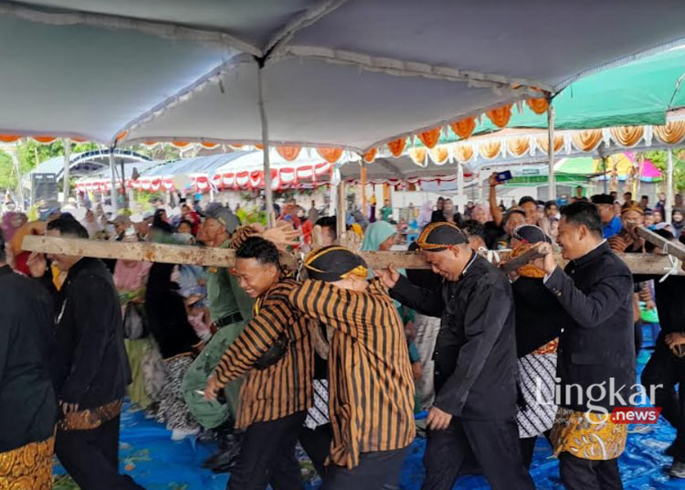 Sejumlah orang sedang memikul luku yang disiram menggunakan dawet dalam prosesi tradisi sedekah bumi ‘Gebyur Dawet’ di Desa Kunir, Kecamatan Dempet, Kabupaten Demak, Selasa sore, 5 Juni 2024. (M Burhanuddin Aslam/Lingkar.news)