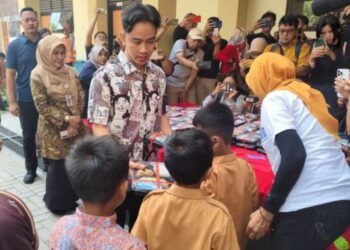 Wakil Presiden terpilih Gibran Rakabuming Raka membagikan makan siang kepada para siswa SDN Tugu Solo, Jawa Tengah, Jumat, 26 Juli 2024. (Antara/Lingkar.news)
