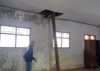 RUSAK: Petugas memeriksa kondisi ruang kelas 4 SDN2 Karangpatihan yang rusak berat di bagian plafon atau langit-langit. (Antara/Lingkar.news)