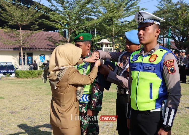 SIMBOLIS: Bupati Demak Eisti’anah saat menyematkan pita kepada anggota yang akan bertugas dalam Operasi Patuh Candi 2024, Senin, 15 Juli 2024. (M. Burhanuddin Aslam/Lingkar.news)