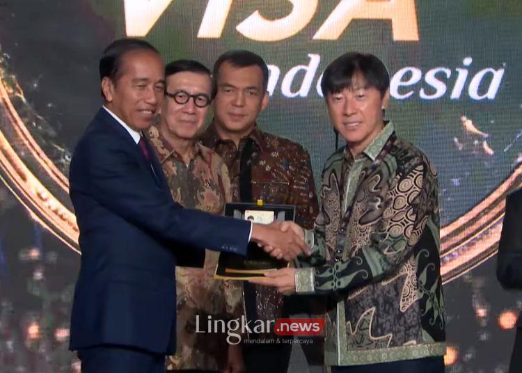 SIMBOLIS: Presiden Joko Widodo (Jokowi) menyerahkan fasilitas Golden Visa kepada Pelatih Tim Nasional Indonesia Shin Tae-yong pada acara Grand Launching Golden Visa yang disaksikan melalui akun YouTube Sekretariat Presiden di Jakarta, Kamis, 25 Juli 2024. (YouTube Sekretariat Presiden RI/Lingkar.news)