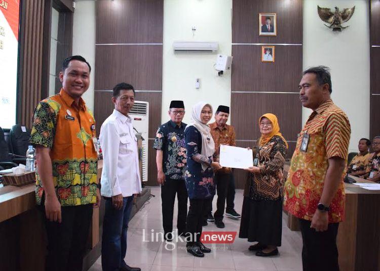 SIMBOLIS: Bupati Demak, Eisti’anah, menyerahkan SK pensiun kepada perwakilan PNS yang akan purna tugas di Gedung Grhadika Binapraja Demak, Rabu, 21 Agustus 2024. (M. Burhanuddin Aslam/Lingkar.news)