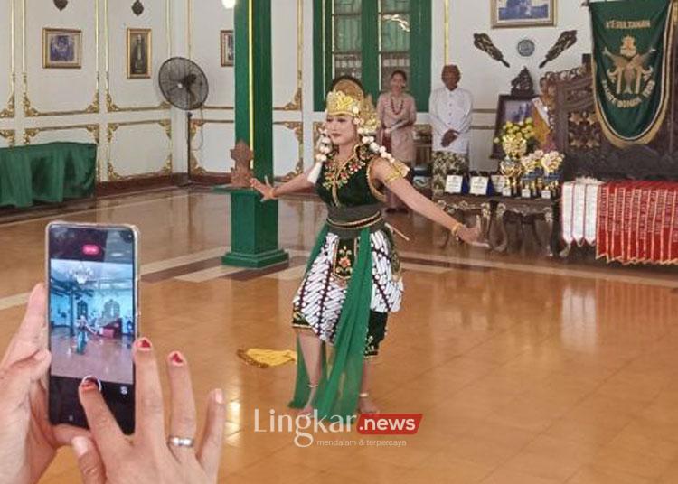 Seorang pengunjung saat mengabadikan momen pertunjukan seni tari yang dipentaskan di Keraton Kacirebonan, Kota Cirebon, Jawa Barat, Minggu (25/8/2024). (ANTARA/Fathnur Rohman)