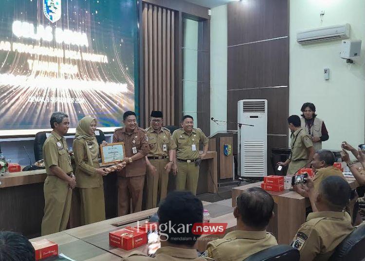 SIMBOLIS: Bupati Demak, Eisti’anah, menyerahkan penghargaan kepada desa dengan predikat desa waskita tanpa cidera di Ruang Grhadika Bina Praja, Senin, 9 September 2024. (M. Burhanuddin Aslam/Lingkar.news)