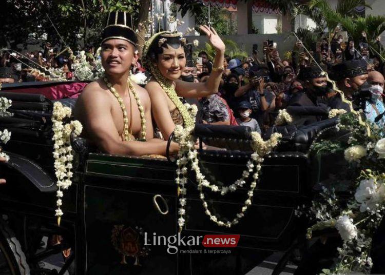 KIRAB: Putra bungsu Presiden Joko Widodo Kaesang Pangarep (kiri) didampingi istrinya Erina Gudono (kanan) menyapa warga saat mengikuti prosesi kirab budaya pada acara Ngunduh Mantu pernikahan di Jalan Slamet Riyadi Solo, Jawa Tengah, Minggu, 11 Desember 2022. (Antara/Lingkar.news)