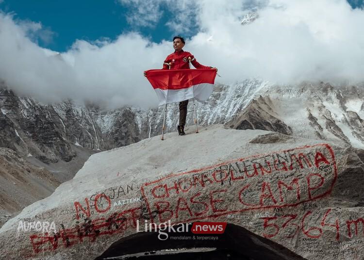Anggi Wahyuda membentangkan bendera Indonesia usai menuntaskan pendakian ke Everest Basecamp yang berada di ketinggian 5.364 mdpl, Nepal, pada Senin, 26 Mei 2025. (Instagram @anggiwahyuda/Lingkar.news)