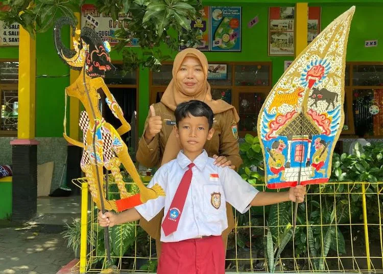 Dalang cilik dari SD 5 Karangbener, Kecamatan Bae, Kabupaten Kudus, Muhammad Suryo Alam didampingi guru. (Nisa Hafizhotus Syarifa/Lingkar.news)
