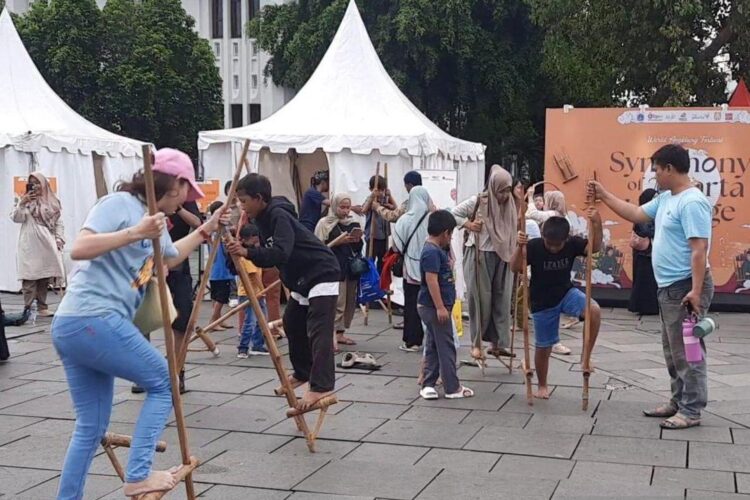 Mainan Egrang Ramaikan Hari Angklung Sedunia ke-15 di Kota Tua Jakarta 1 Pengunjung Kota Tua, Jakarta menaiki egrang di sela Puncak Hari Angklung Sedunia
ke-15 (World Angklung Day), Minggu (23/11/2025). ANTARA/Lia Wanadriani Santosa.