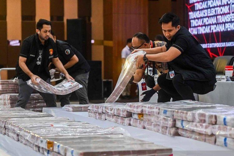 Sejumlah petugas memindahkan barang bukti uang tunai senilai Rp204 miliar untuk
ditampilkan saat pengungkapan kasus pembobolan rekening pasif di Gedung
Bareskrim Polri, Jakarta, Kamis, 25 September 2025 lalu.  (Antara)