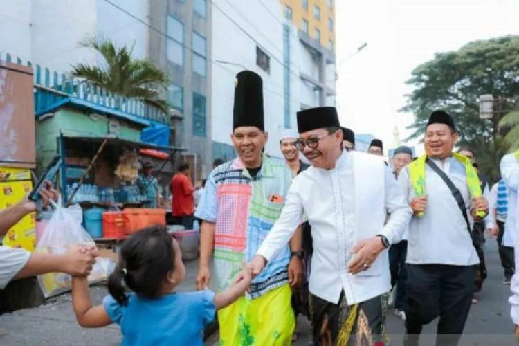 Jalan Sehat Sarungan Kota Tangerang Diikuti 5.000 Peserta Festival Al-A’zhom 1 Wali Kota Sachrudin bersalaman dengan seorang anak kecil saat melakukan jalan
sehat sarungan bersama ribuan warga, Minggu. ANTARA/LINGKAR NETWORK.