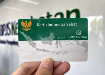 Seorang warga menunjukkan KIS. Baru-baru ini ribuan peserta PBI BPJS Kesehatan dinonaktifkan sepihak. (Red – Lingkar.news)