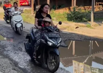Sejumlah pengendara melintas di ruas jalan Godo-Sinomwidodo, Pati yang rusak parah. DPRD Pati memastikan anggaran sudah siap untuk perbaikan. (Red – Lingkar.news).