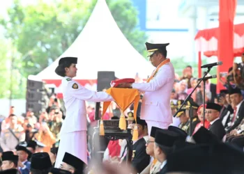 Gubernur Sulteng Anwar Hafid memberikan Sang Merah Putih pada pembawa baki untuk dikibarkan dalam upacara Detik-Detik Proklamasi HUT ke-81 RI di Sulawesi Tengah, Senin (17/8/2026)> (LINGKAR.news Network)