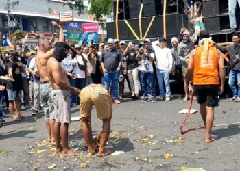 Pendemo telur Pati memecahkan telur di depan Kantor Bupati Pati. (Mutia P – LINGKAR.news)