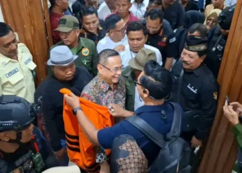 Bupati Pati nonaktif Sudewo hendak mengenakan rompi oranye usai sidang replik di Pengadilan Tipikor Semarang, Rabu (7/10/2026). (Rizky Syahrul/Asih)