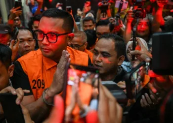 Bupati Klaten Hamenang Wajar Ismoyo (kiri) berjalan menggunakan rompi tahanan usai menjalani pemeriksaan di Gedung Merah Putih KPK, Jakarta, Jumat (16/10/2026).